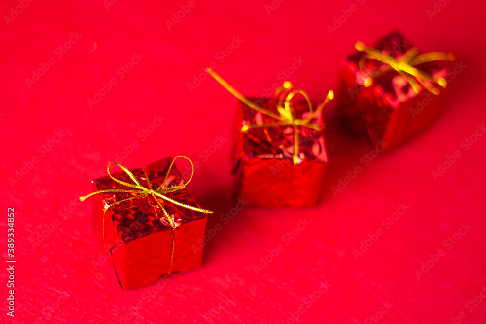 Christmas decorations on a red background. Holiday decorations. Three red gifts on a red background. Christmas concept