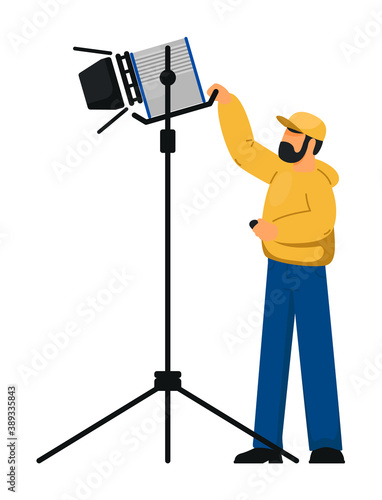 Man lighting technician with spotlight equipment on white