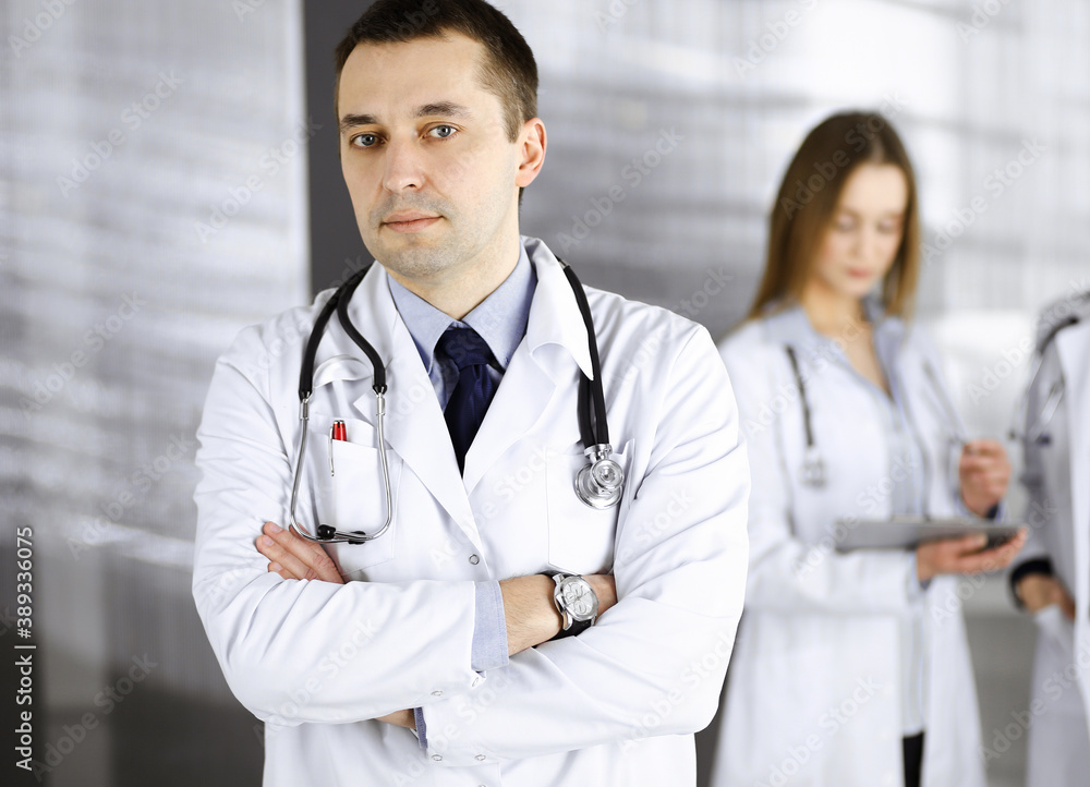 Professional middle aged doctor with a stethoscope and crossed arms at work in a clinic. Perfect medical service in a hospital. Medicine and healthcare concept Professional middle aged doctor with a stethoscope and crossed arms at work in a clinic. Perfect medical service in a hospital. Medicine and healthcare concept