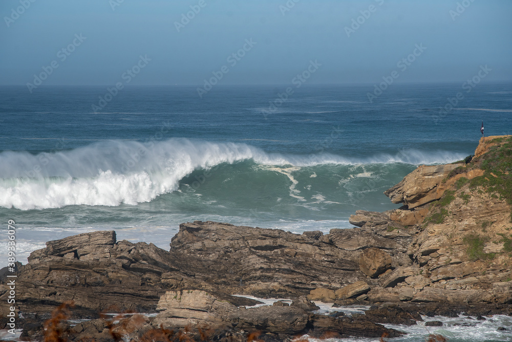 ola grande rompiendo en una costa de rocas 