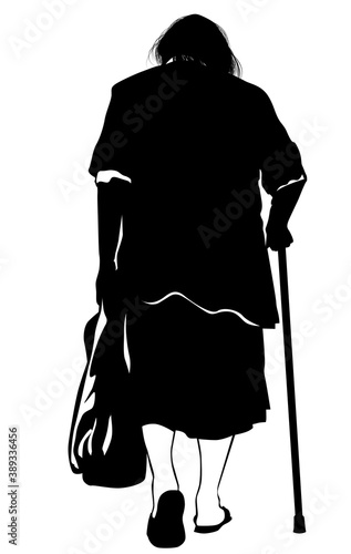Silhouette of an elderly woman walking with a bag and crutch in her hands
