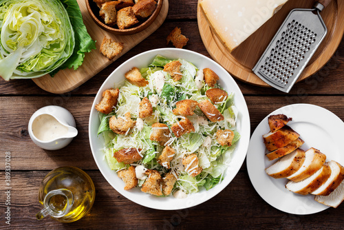 Classic caesar salad with grilled chicken fillet and parmesan cheese. top view	 photo