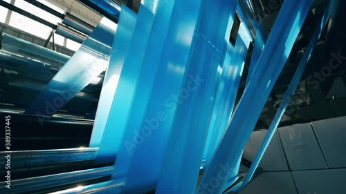 Blue polyethylene foil rolling through the factory reels