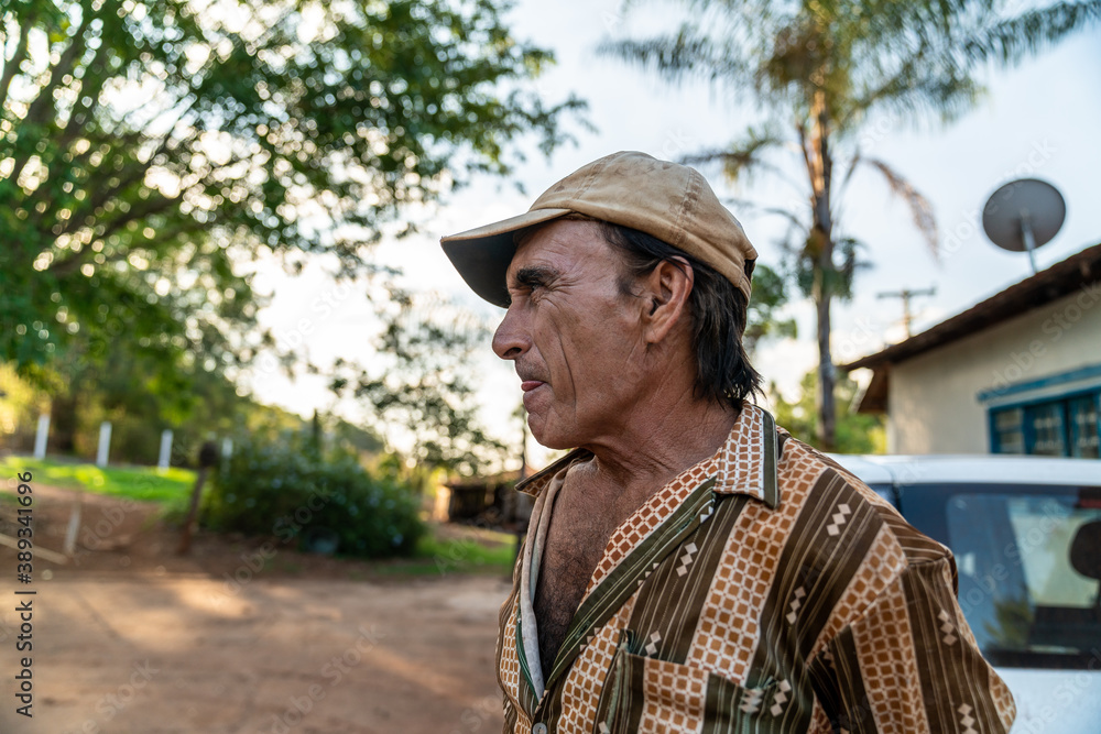 Portrait of smiling beautiful male farmer. Man at farm in summer day. Gardening activity. Brazilian elderly man. Latino people.