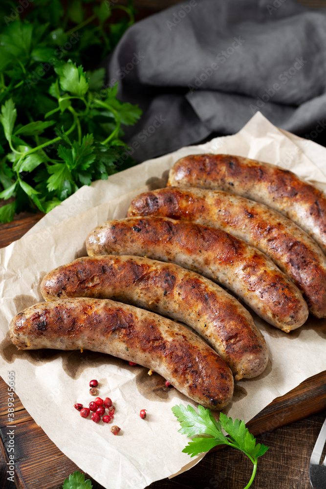 Fried sausages. Grilled sausages with spices on a wooden serving Board. Delicious meat sausages Fried sausages. Grilled sausages with spices on a wooden serving Board. Delicious meat sausages