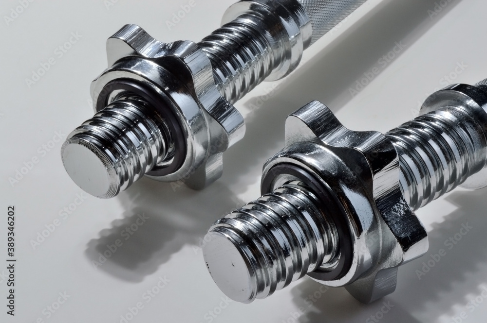 chrome bar from dumbbells on a white background close-up. chrome bar from dumbbells on a white background close-up.