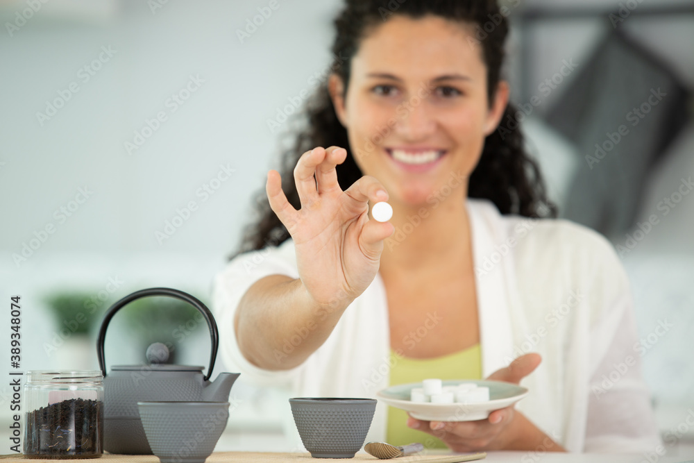 young woman adding sugar in tea young woman adding sugar in tea