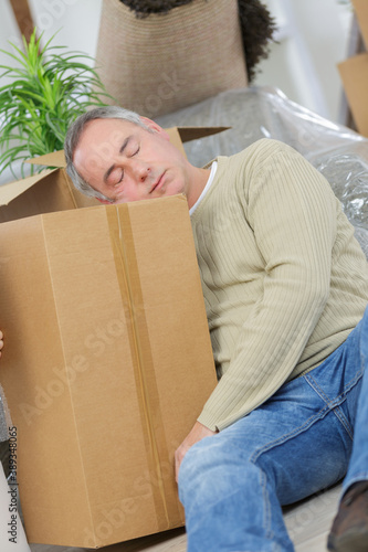 tired man sleeping on cardboard boxes around