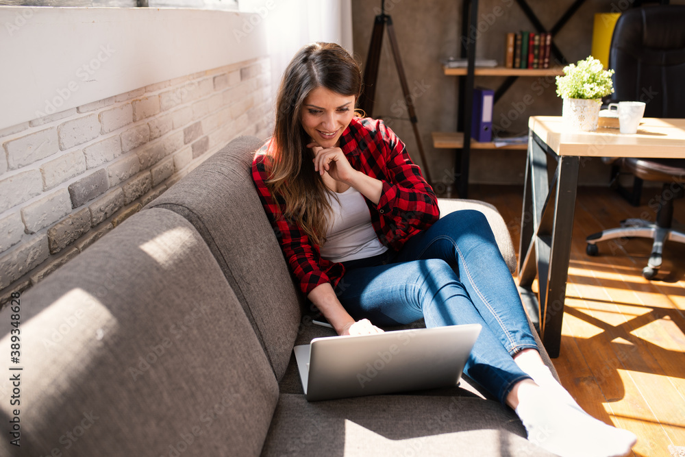 Obraz premium Woman teleworker works at home with a laptop. She is in smart working due to covid-19 pandemic