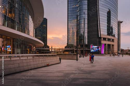 People walking during sunset in Gae Aulenti square, in the new Porta Nuova district in Milan photo