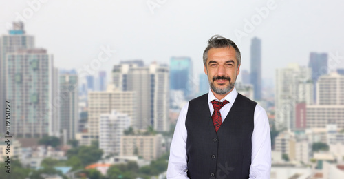 Senior Caucasian businessman with formal wear standing with cityscape in urban panorama view with copy space
