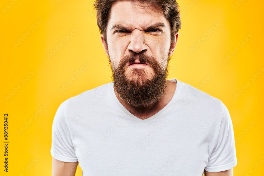 emotional bearded man in t-shirt cropped view yellow background studio emotional bearded man in t-shirt cropped view yellow background studio