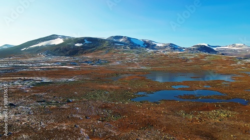 Rugged wild mountain highlands with frozen wetlands and snow covered mountain peaks in the distance. 