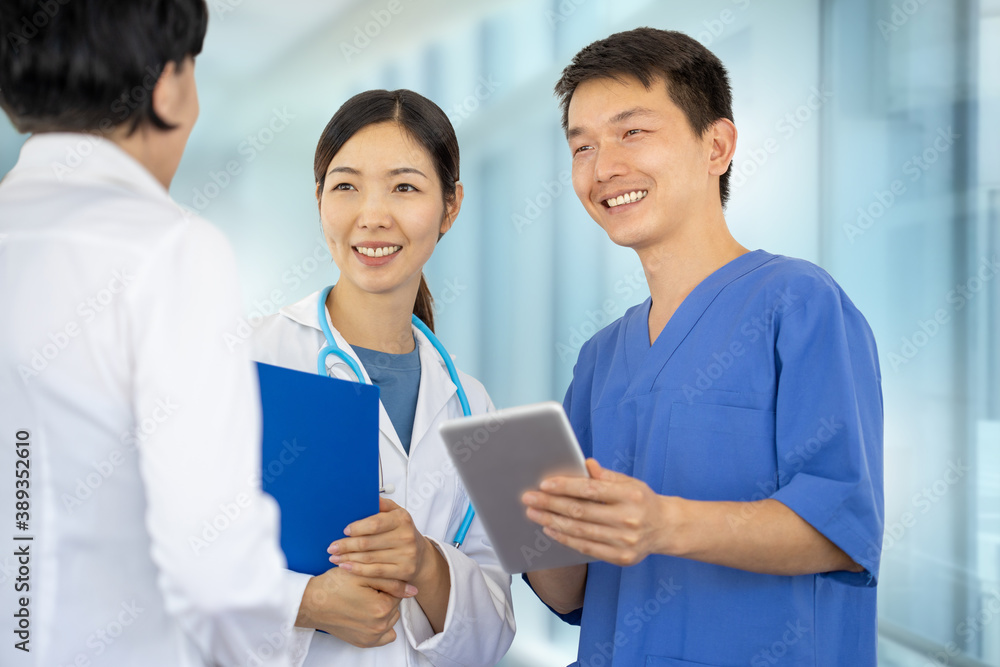Asian woman doctor with white coat and stethoscope together with a man surgeon with tablet make a consultation in the hospital Asian woman doctor with white coat and stethoscope together with a man surgeon with tablet make a consultation in the hospital