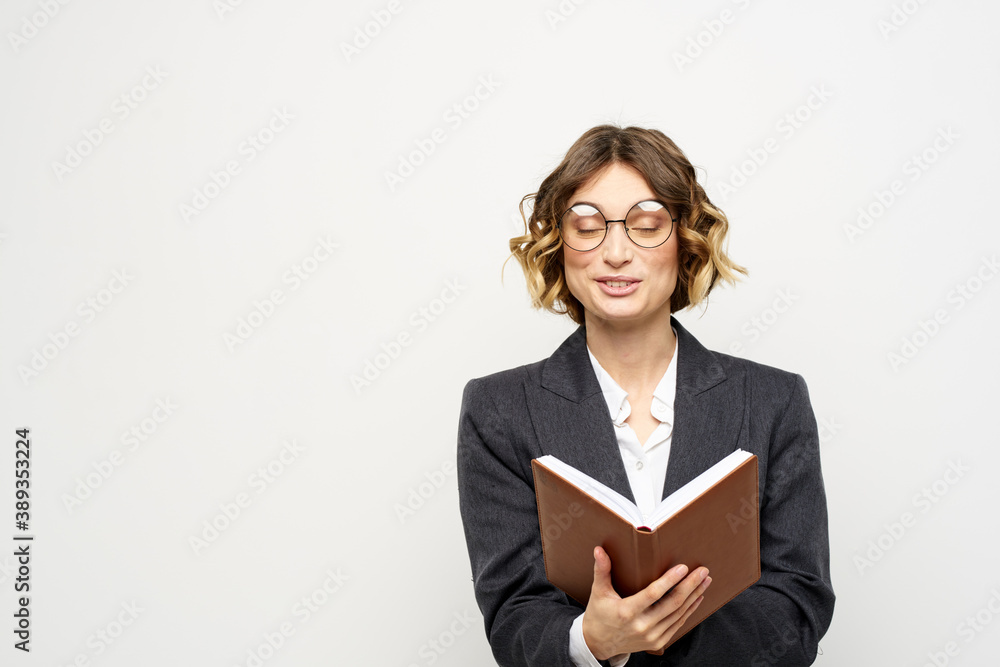 Woman at work with book in hand light background classic suit glasses head Woman at work with book in hand light background classic suit glasses head