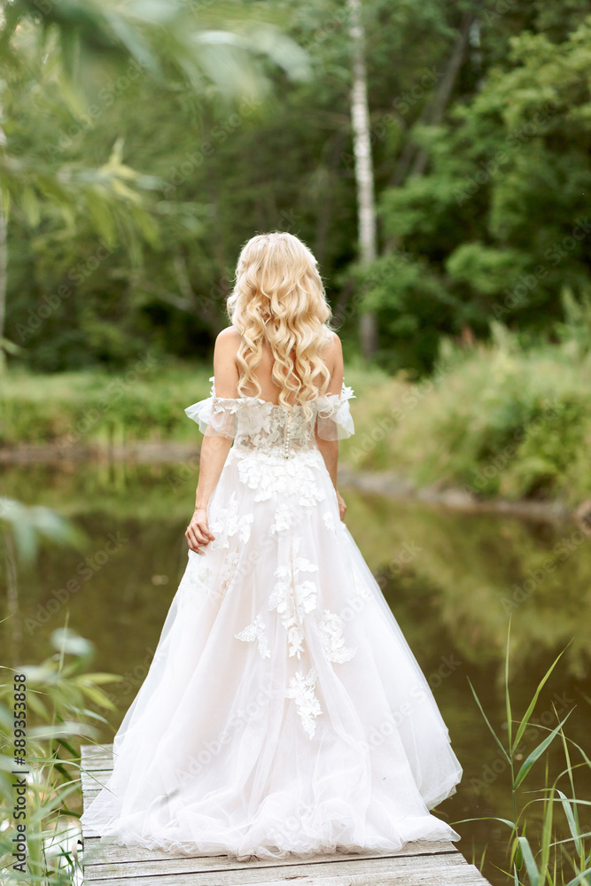 portrait of the bride in a beautiful wedding dress, blonde, gentle photo wedding portrait in nature. Back view, no face. portrait of the bride in a beautiful wedding dress, blonde, gentle photo wedding portrait in nature. Back view, no face.