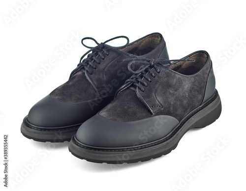 Great pair of brutal men's shoes combined from black suede and waterproof inserts on the toe and heel, on a solid sole, isolated on a white background with shadow.