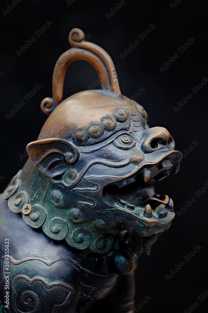 Fototapeta premium Chinese guarding statue of a beast on a black background