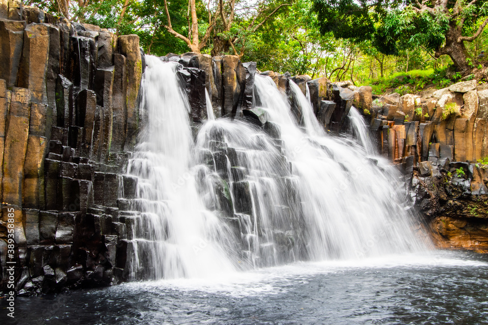 Obraz premium A small beautiful waterfall with the rocks.
