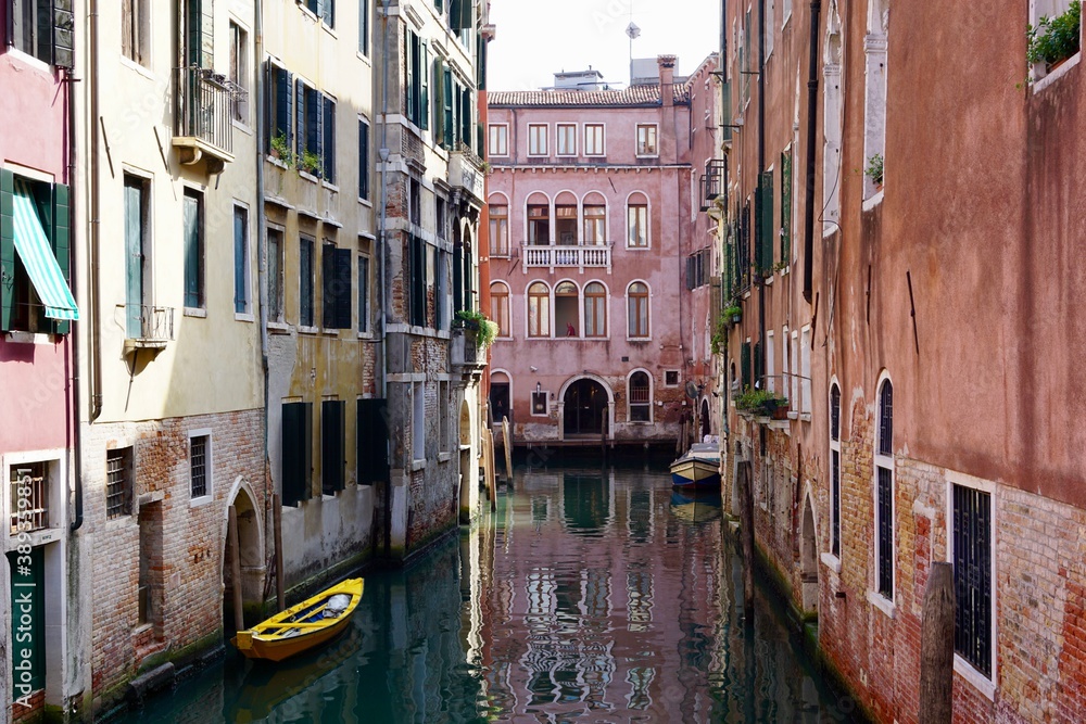 Bunter Kanal in Venedig im Sommer mit einem gelben Boot, Italien