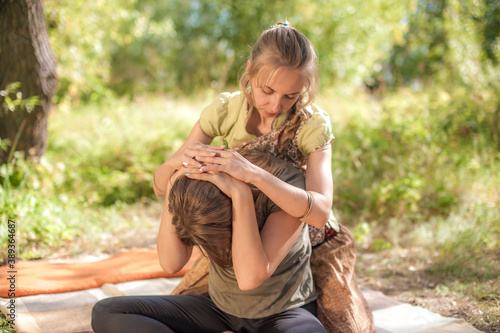 Woman masseuse provides a thorough massage on the forest floor. photo