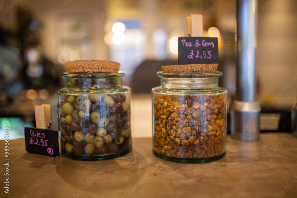 Dehydrated olives and peas in glass jars on the counter of a vegan restaurant Dehydrated olives and peas in glass jars on the counter of a vegan restaurant