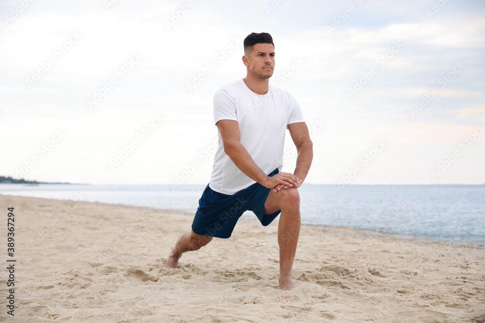 Muscular man doing exercise on beach. Body training Muscular man doing exercise on beach. Body training
