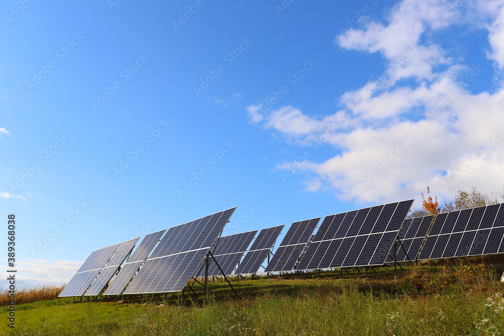 Solar panel on a background of blue sky with clouds and the sun reflected on the panel. The concept of alternative environmental energy Solar panel on a background of blue sky with clouds and the sun reflected on the panel. The concept of alternative environmental energy
