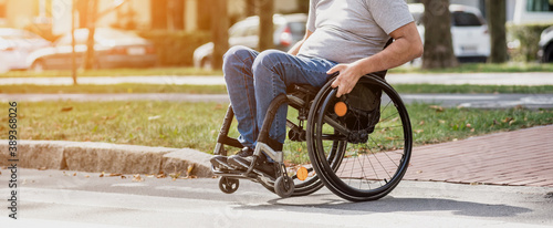 Handicapped man in wheelchair crossing street road