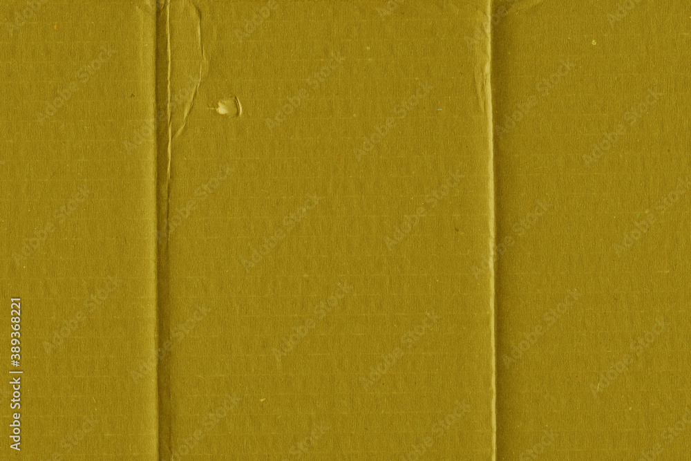 Fototapeta premium A yellow vintage rough sheet of carton. Recycled environmentally friendly cardboard paper texture. Simple and bright minimalist papercraft background.