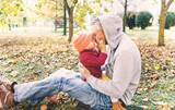 happy dad plays with his little daughter in the Park on autumn leaves