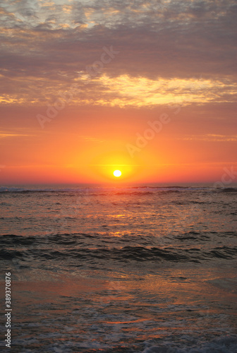 Por-do-sol na praia com textura de nuvens no céue reflexo na água do mar, portrait, retrato