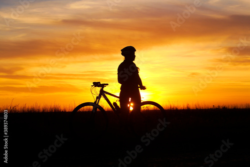 silhouette of a person with a bicycle