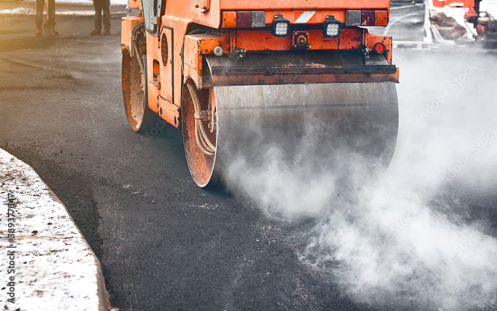 Vibration roller compactor lay new asphalt surface in wintertime. Road construction, asphalt roller press hot asphalt. Asphalt paving, steamroller machine Vibration roller compactor lay new asphalt surface in wintertime. Road construction, asphalt roller press hot asphalt. Asphalt paving, steamroller machine