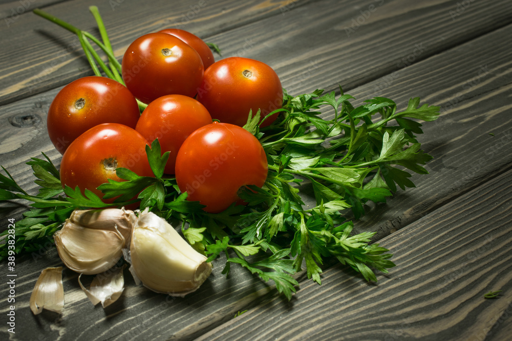 tomatoes, parsley and garlic are on an old table tomatoes, parsley and garlic are on an old table