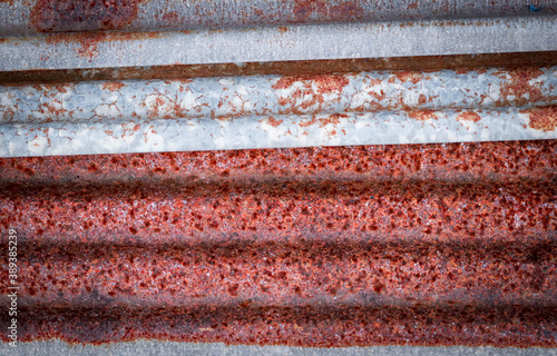 Sharp edges of the rusty metal sheets placed on the floor. Old aged weathered rusty galvanized corrugated iron sheet roof of abandoned mood. selective focus blur background. Vintage.