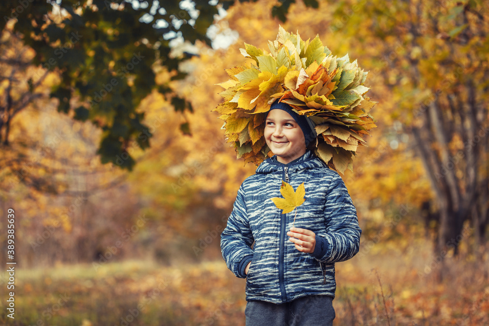 happy kid in the autumn forest wearing a wreath of yellow leaves happy kid in the autumn forest wearing a wreath of yellow leaves