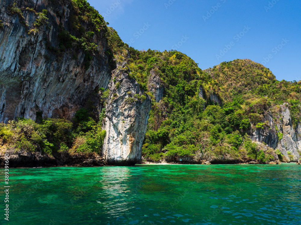 Turquoise sea, rocky coast, clear blue sky.