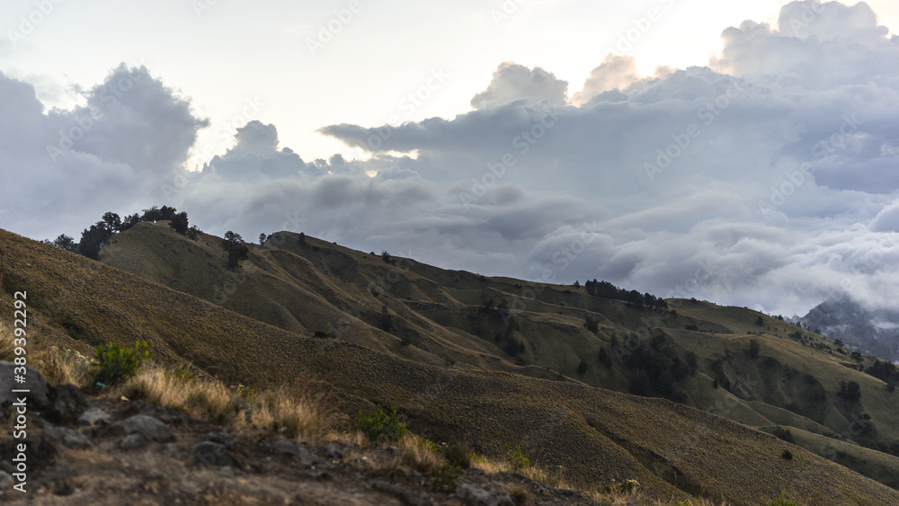 landscape with clouds, panorama of the mountains in the morning, sunrise over the hills and mountains with fluffy clouds, Lombok Island, Indonesia