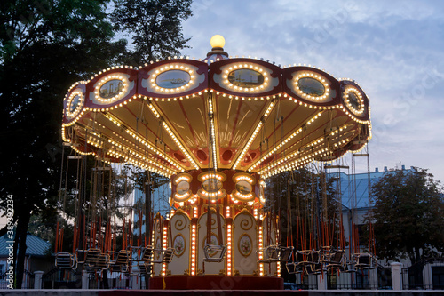Beautiful colored carousel in a winter park at sunset.