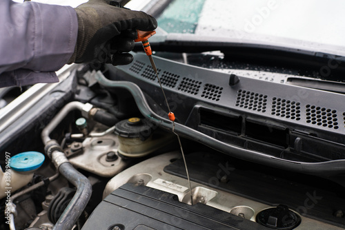 Mechanic man checking engine oil refill car maintenance © themorningglory