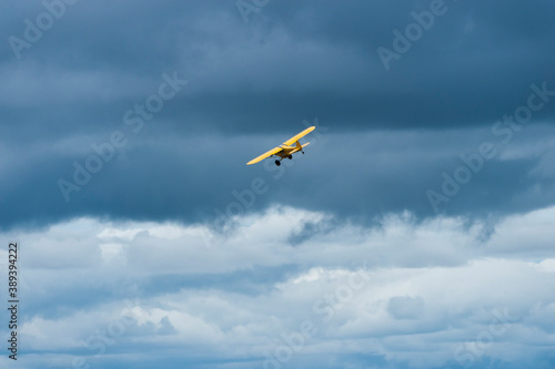 Yellow plane flying over Masai Mara looking for poachers, with blue cloudy sky in background, masai mara, Kenya, Africa, may 2013