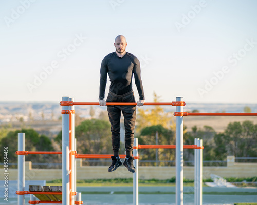 Persona entrenando al aire libre en un parque de barras, fitness