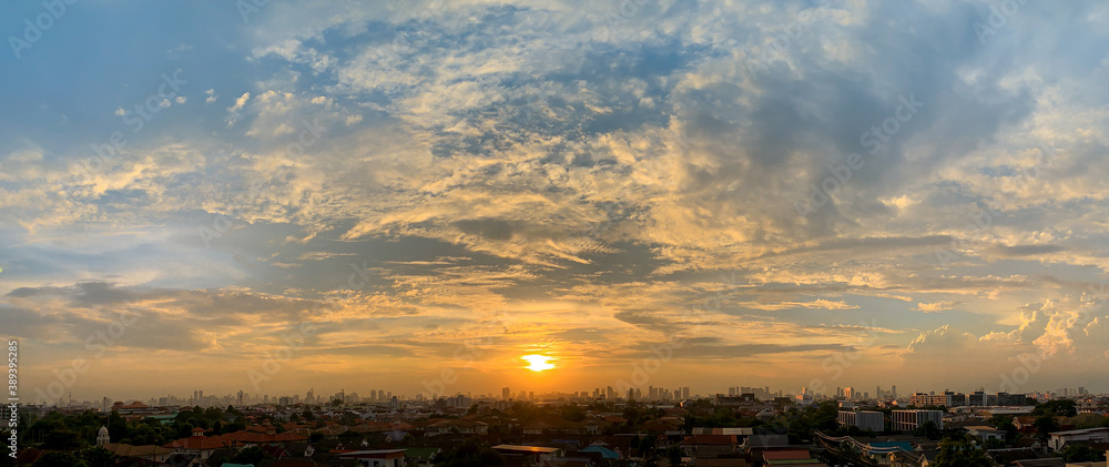 Silhouette of the Bangkok city with an afternoon sunset and epic sky clouds. Wide aspect ratio.