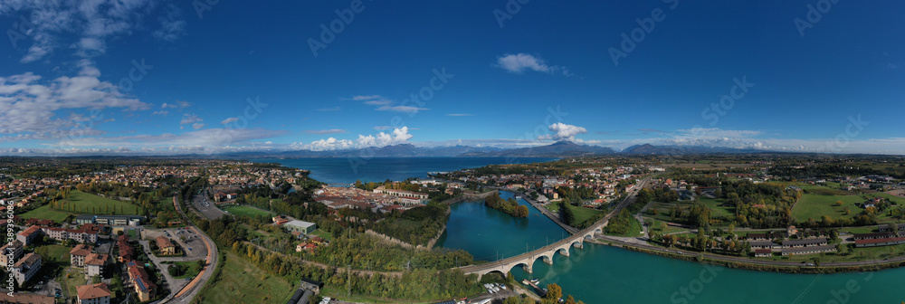 Peschiera del Garda, Italy. Aerial panorama of the resort town on Lake Garda. Italian town on the lake. Small town on the water against the background of water and high mountains top view.