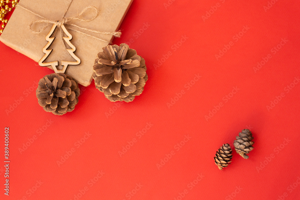 Naklejka premium Christmas red background, craft gift pine cones gold beads snowflakes. Christmas red background