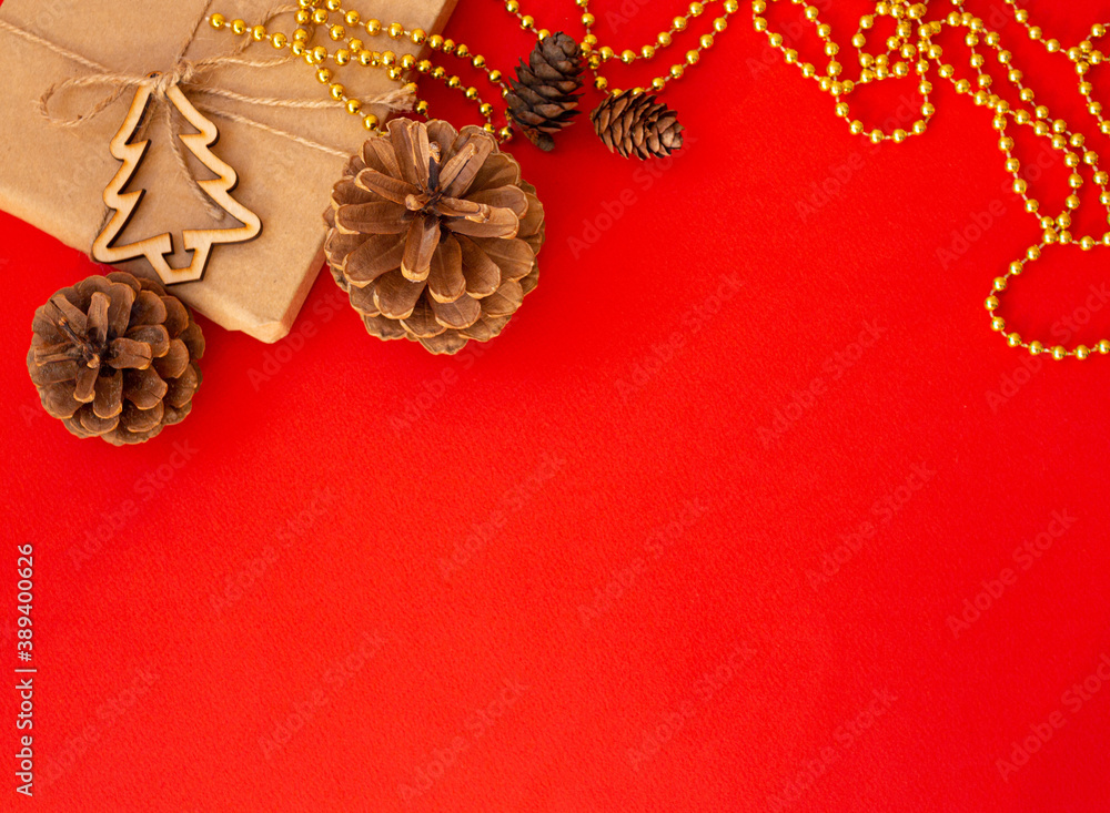 Christmas red background, craft gift pine cones gold beads snowflakes. Christmas red background
