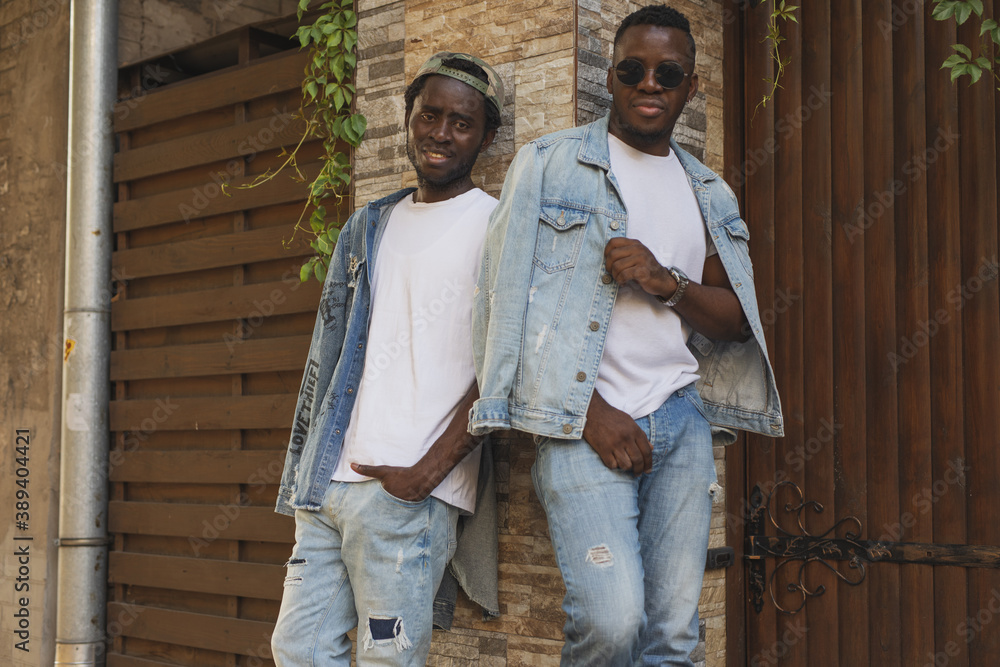 Happy african man in jeans jacket on the background brick wall Happy african man in jeans jacket on the background brick wall