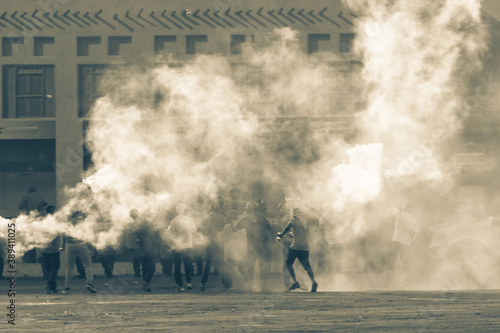 Картината върху платно Military police riot response to a protest with tear gas, smoke, fire, explosions
