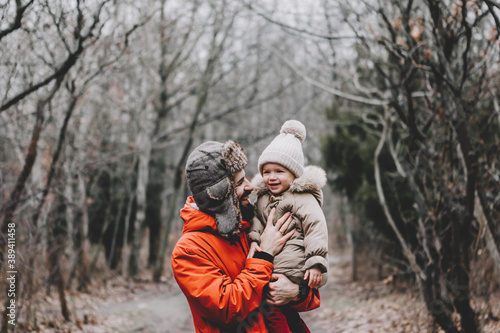 Happy loving family! Father and his daughter playing and hugging outdoors. Lovely little girl and dad on a winter walk in nature. Frosty winter season concept.